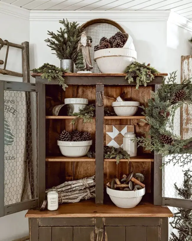 A Hutch Display with Greenery & Pinecones