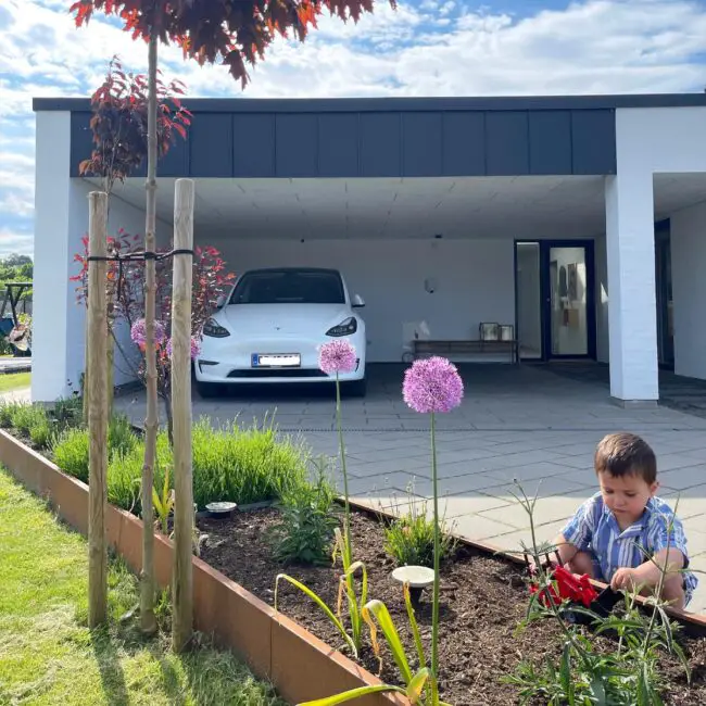 Spacious Carport Harmoniously Blending With Garden Elements